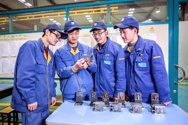鉗工課上同學們在研究學長們的作品討論加工工藝